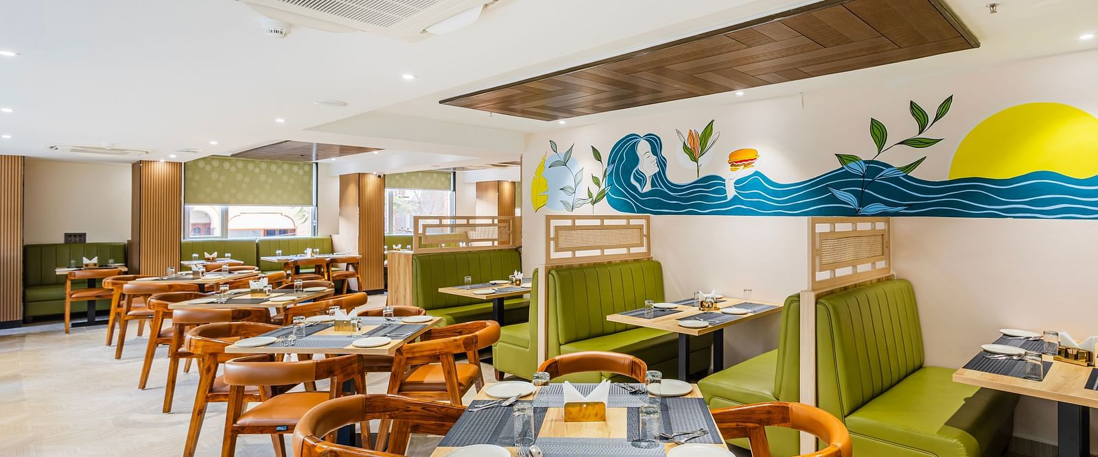 Lemonridge Hotels, KPHB | Dining area with tables and chairs, showcasing the artistic wall decor and ceiling design.